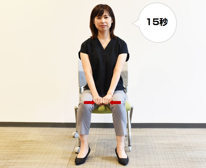 イスに座ったまま足を少し開き、ひざの間に両手の握りこぶしを横並びに置く