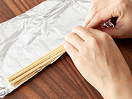 割り箸2膳分を上下互い違いに重ねてアルミホイルで巻き、芯にする。