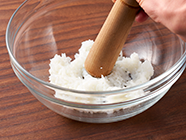 ボウルに白ご飯を入れ、すりこぎ棒でつぶします。