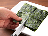 焼き海苔を十字にカットして4等分にし、海苔4辺の真ん中あたりに3cm深さの切り込みを入れて、包みやすくする。