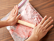 食べる直前に袋の上からで麺棒などで固まりを押しつぶし、食感をなめらかにさせる。カットした飾り用のイチゴを添える。