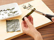 パプリカは縦半分に切り、種を取り除く。焼き海苔はランタンの顔(目・鼻・口)4個分をハサミでカットする。