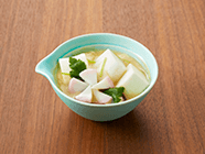 出来上がりにかまぼこを花型にのせ、三つ葉の葉を散らします。