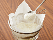 ボウルの上にひと回り大きいザルをのせ、キッチンペーパーを敷いてヨーグルトを入れる。
                                    ザルの上からラップをかけて冷蔵庫で2時間から一晩ほど置き、水を切る。