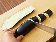 ナスは縦半分に切った後、一口大に切る。ポリ袋に切ったナス・〈A〉を加えて揉み込み、10分ほど置く。