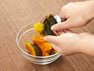 冷凍カボチャは耐熱ボウルに入れてラップをかけ、電子レンジ(500w)で約4分加熱し、スプーンや包丁を使って皮を薄く取り除き、滑らかになるまでつぶして砂糖を混ぜ合わせる。