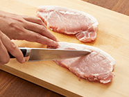 豚肉は筋の部分に数カ所包丁を入れて、筋切りをする。