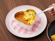 チキンライス・オムレツの順にのせ、アルミホイルを外す。温め直したデミ風ソース・生クリームをかせ、パセリを散らす。